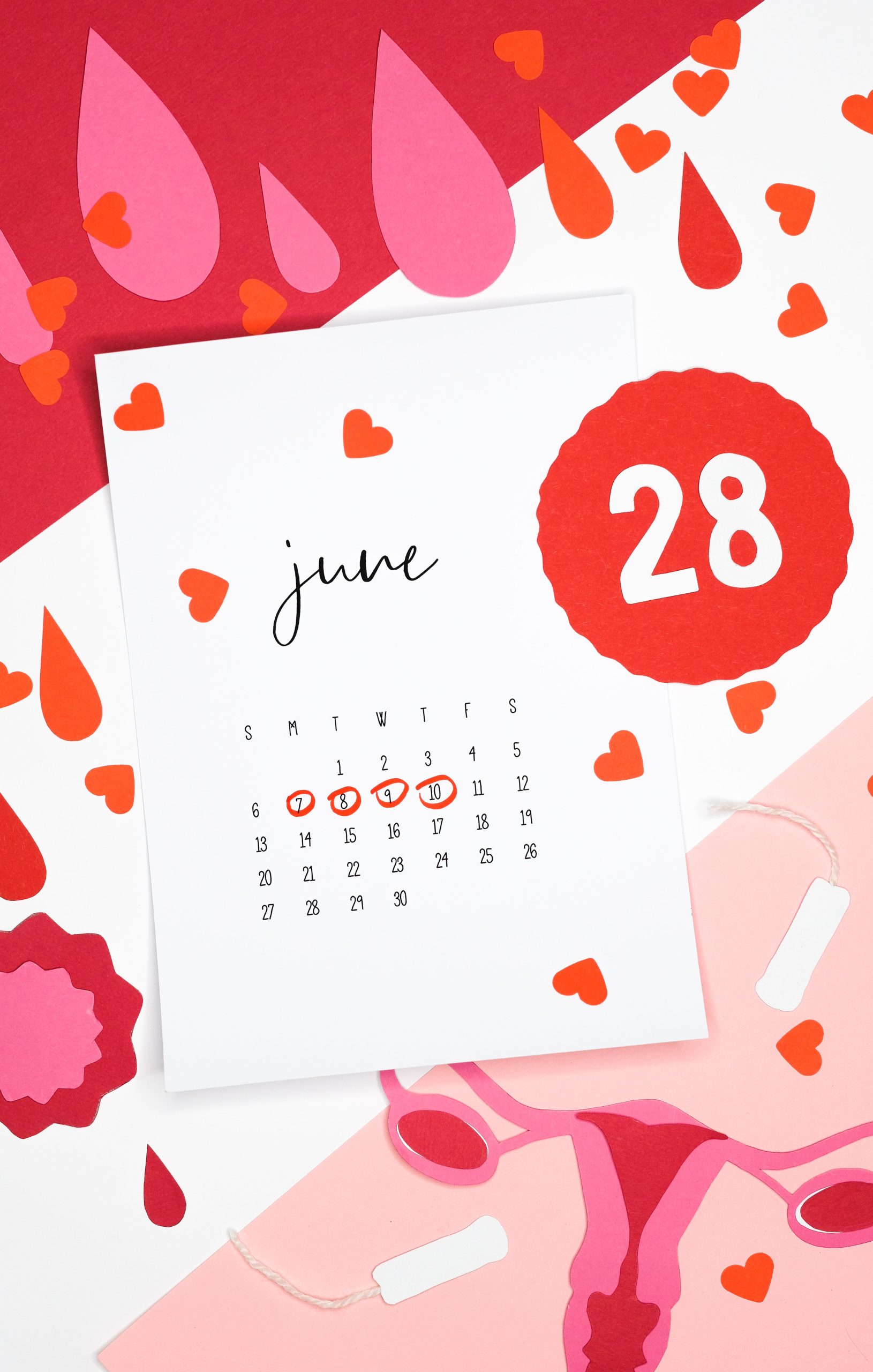 Artistic still life of a June calendar with heart and blood drop cutouts symbolizing the menstrual cycle. Composition artistique d'un calendrier de juin avec des découpes en forme de cœur et de goutte de sang symbolisant le cycle menstruel.