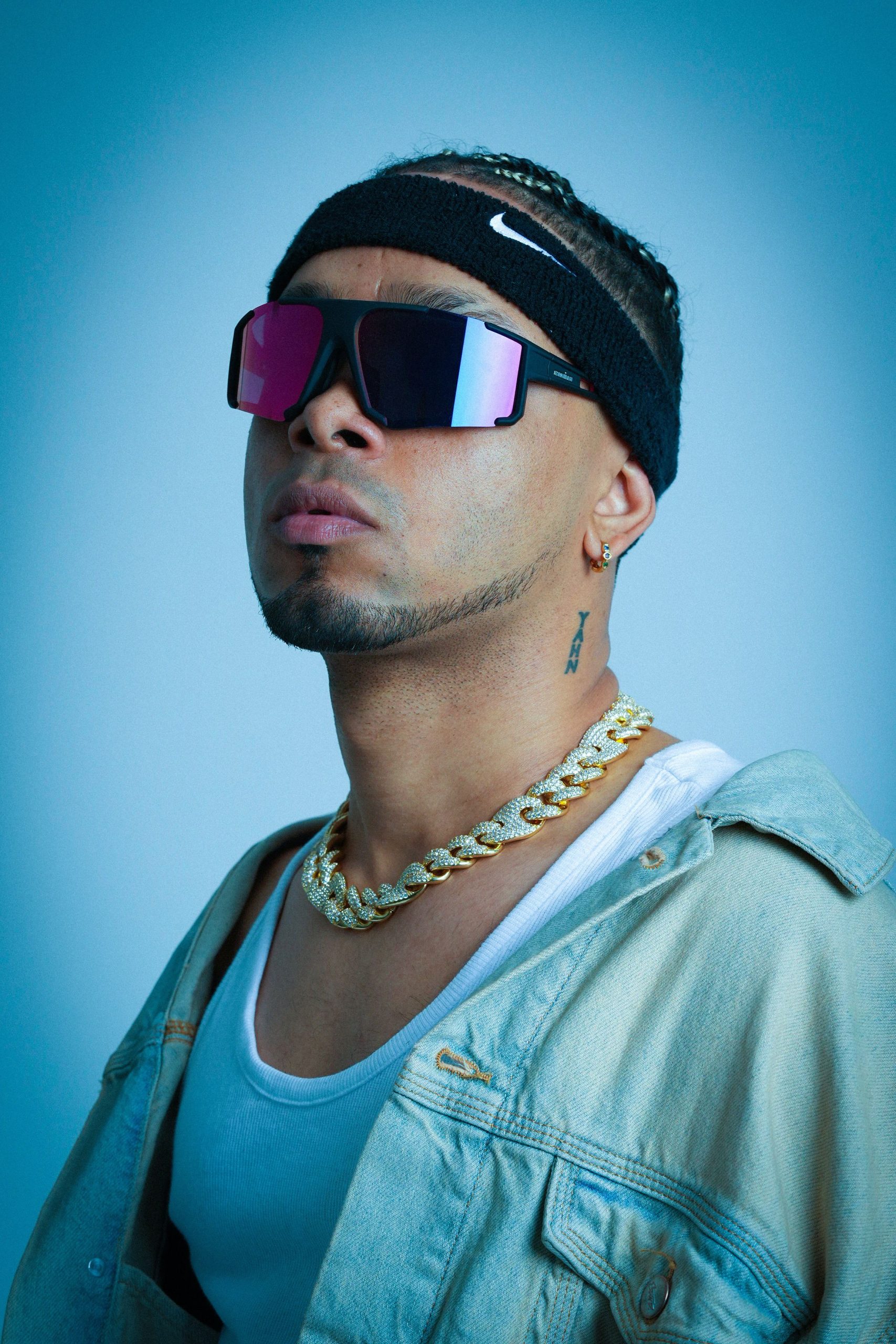 A modern portrait of a stylish music artist wearing sunglasses and a chain, exuding urban vibes. Portrait moderne d'un artiste musicien élégant portant des lunettes de soleil et une chaîne, dégageant des vibrations urbaines.