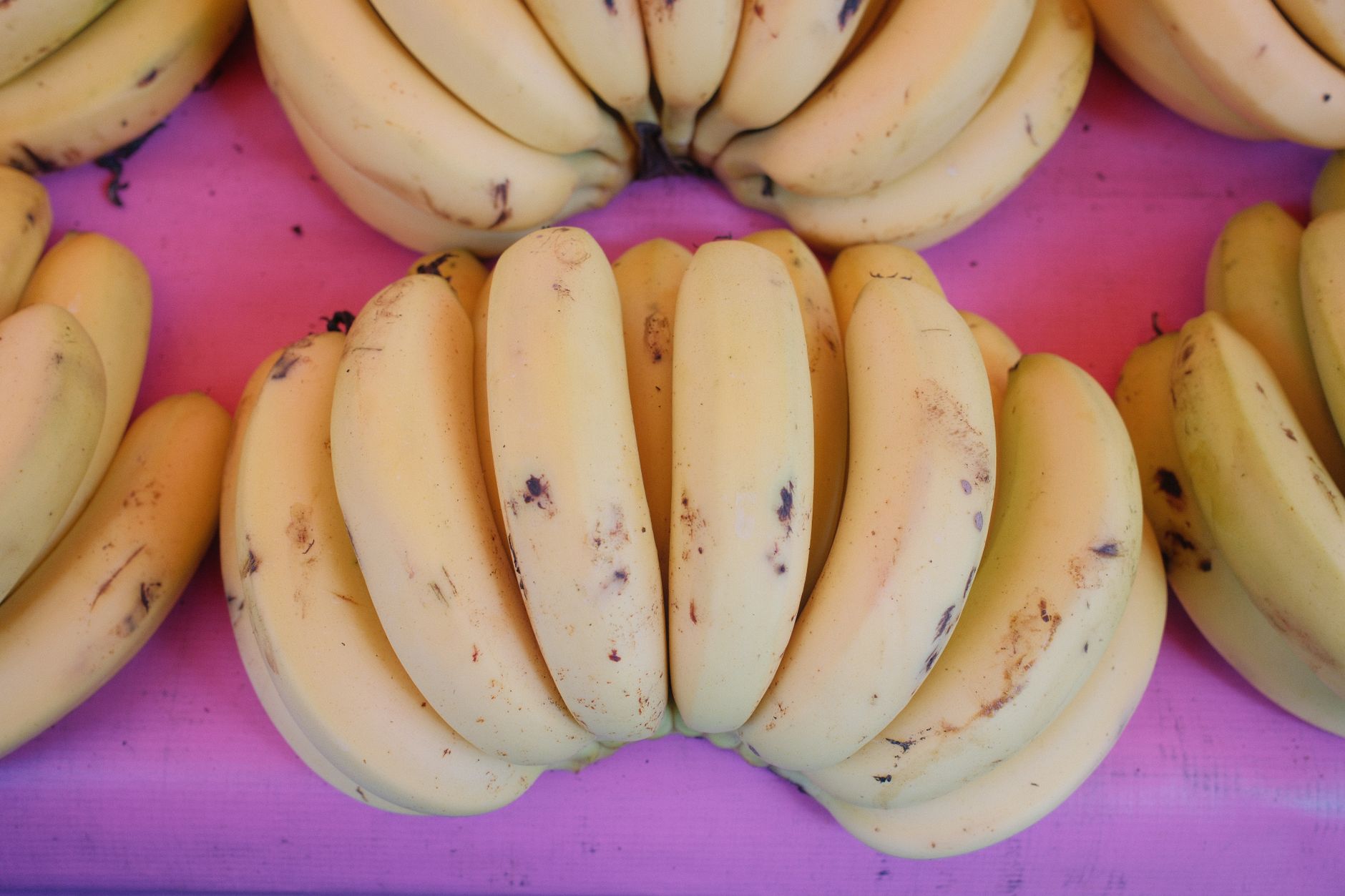 Bananes jaunes bien mûres sur fond rose