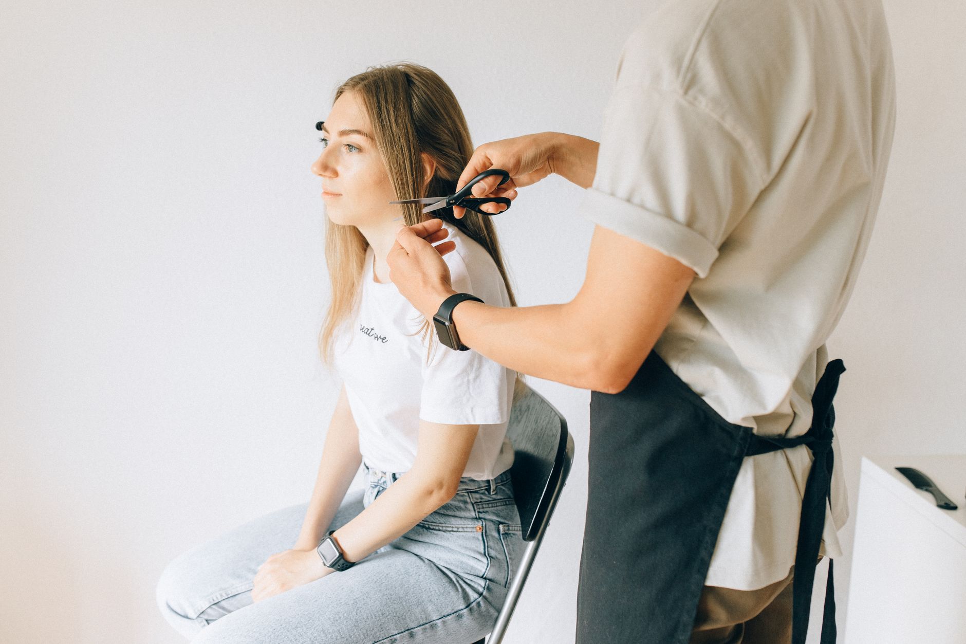 Coiffeuse coupant les cheveux longs, profil femme