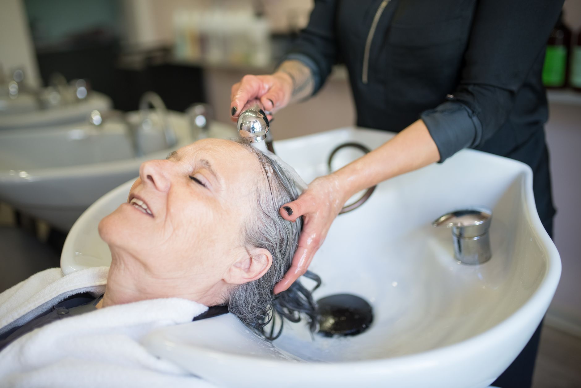 Coiffeuse qui examine le cuir chevelu d’une cliente