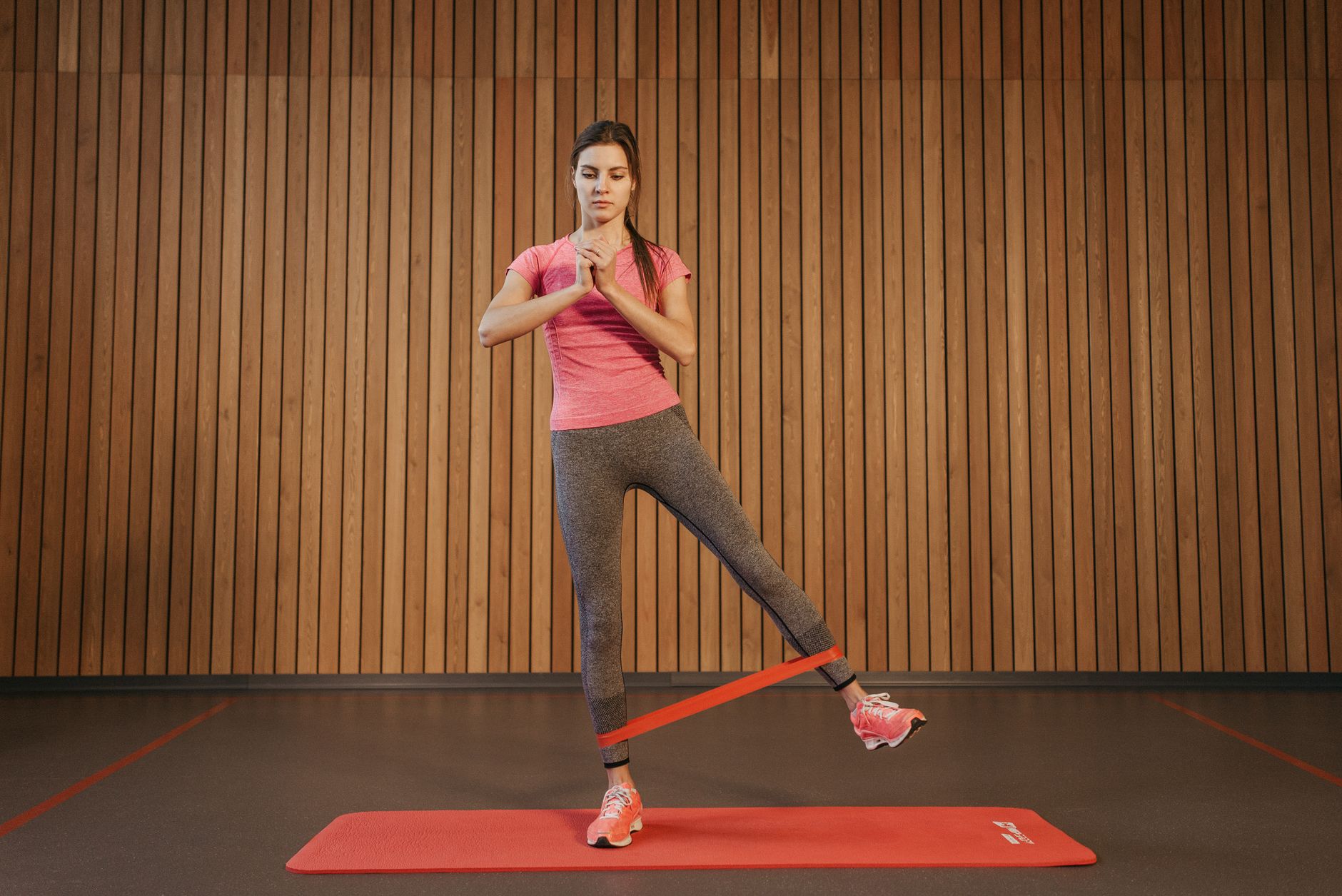 Femme qui exécute un exercice de jambes avec élastique en salle