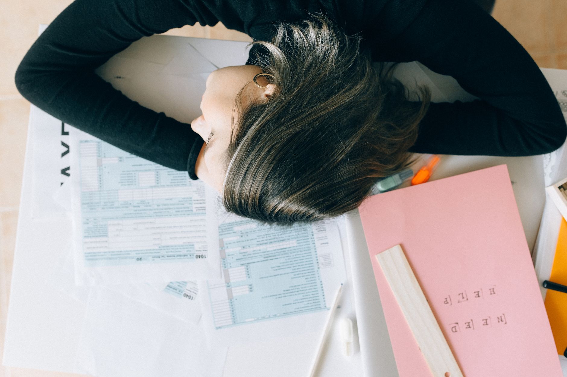 Femme fatiguée, tête posée sur des documents au bureau