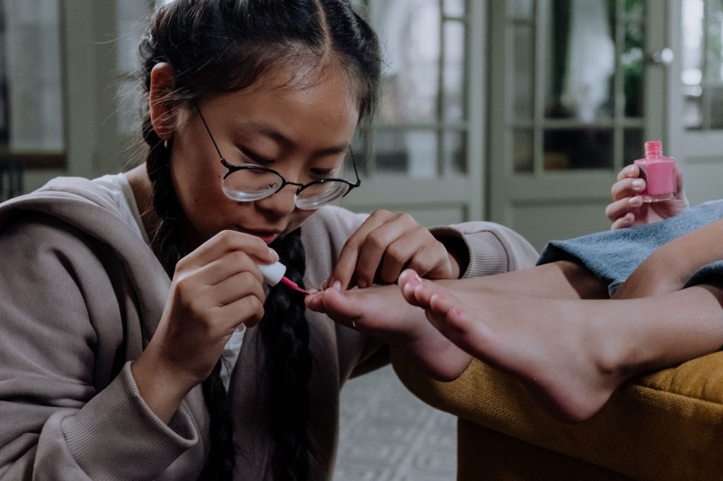 Jeune femme qui applique du vernis à ongles