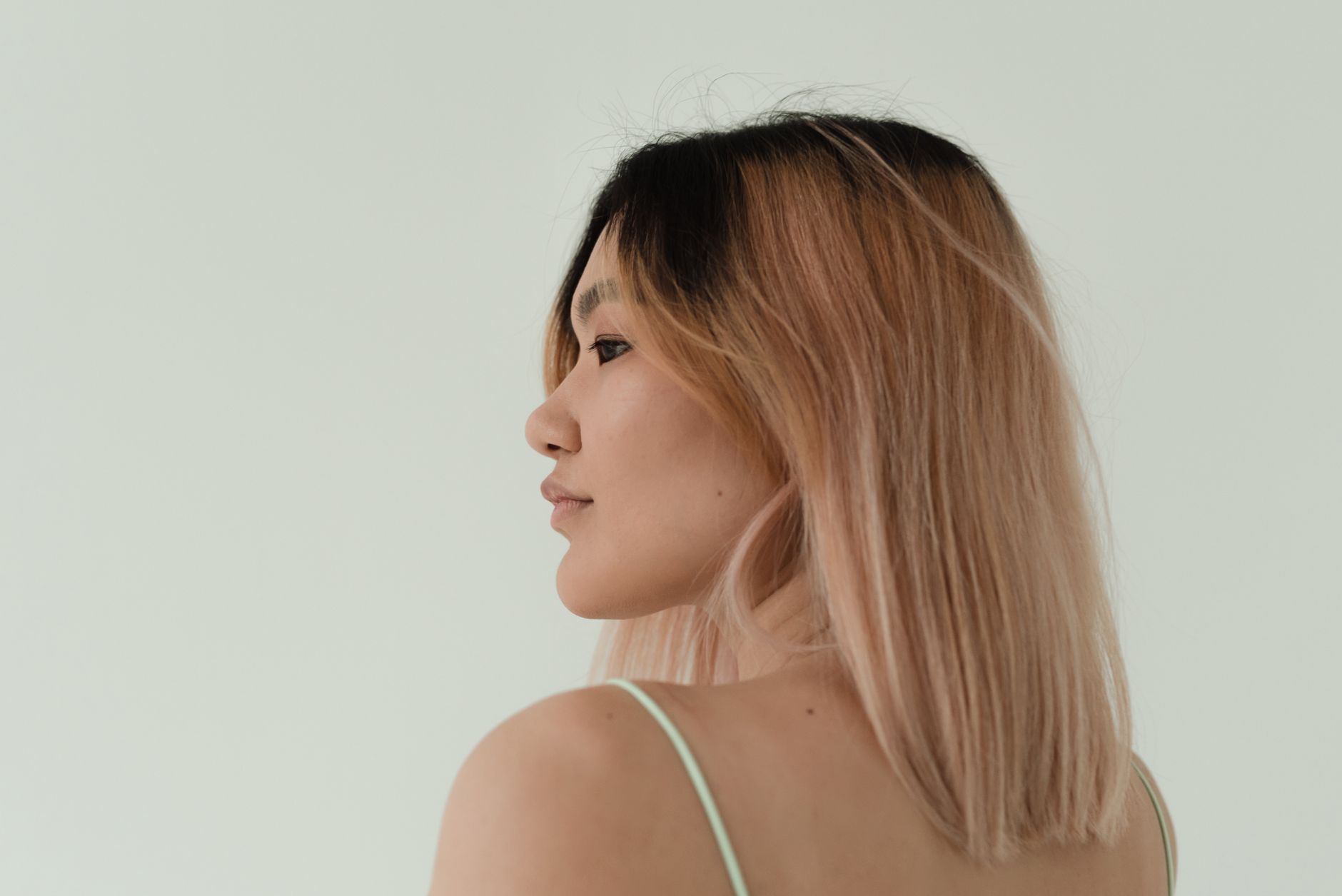 Cheveux avec un balayage rose p&acirc;le sur fond neutre