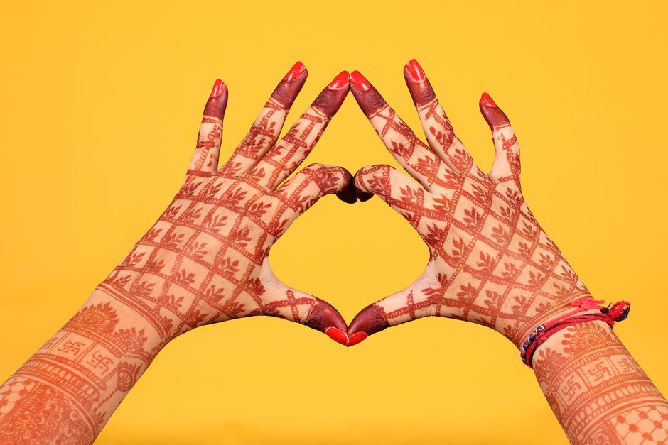 Mains ornées de motifs au henné en forme de coeur