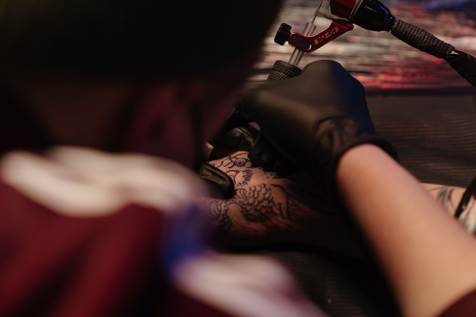 Machine à tatouer utilisée pour dessiner un motif sur un bras