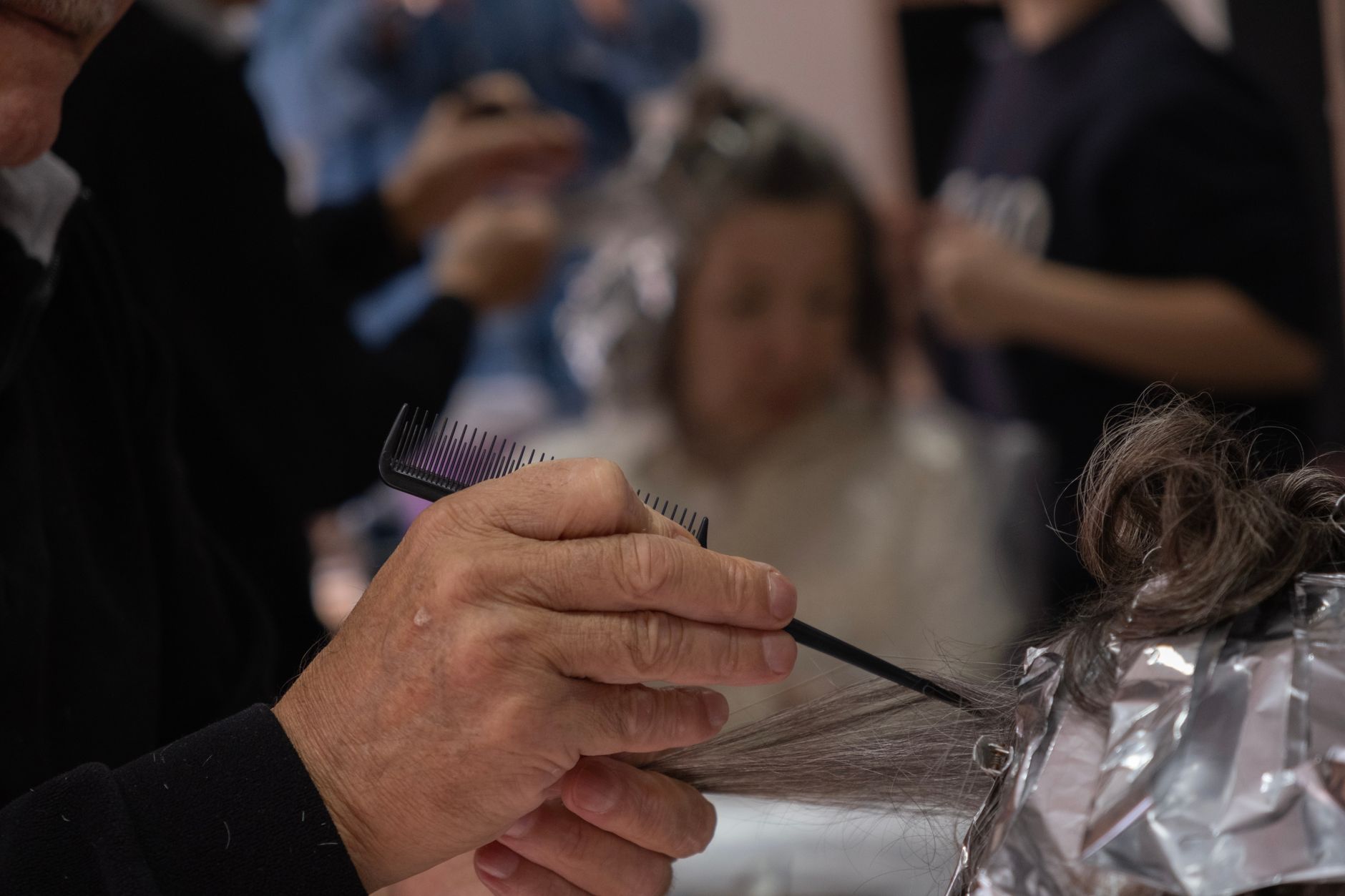 Coiffeuse qui réalise des mèches sur des cheveux