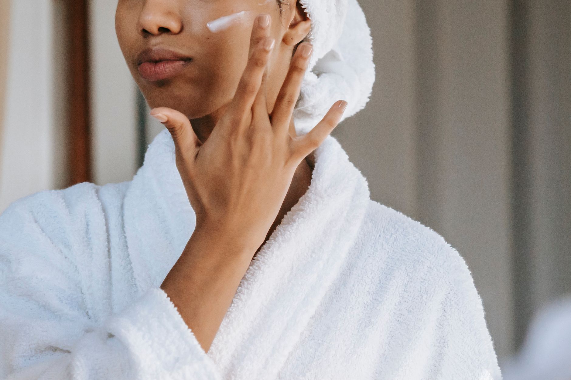 Femme appliquant une crème sur le visage