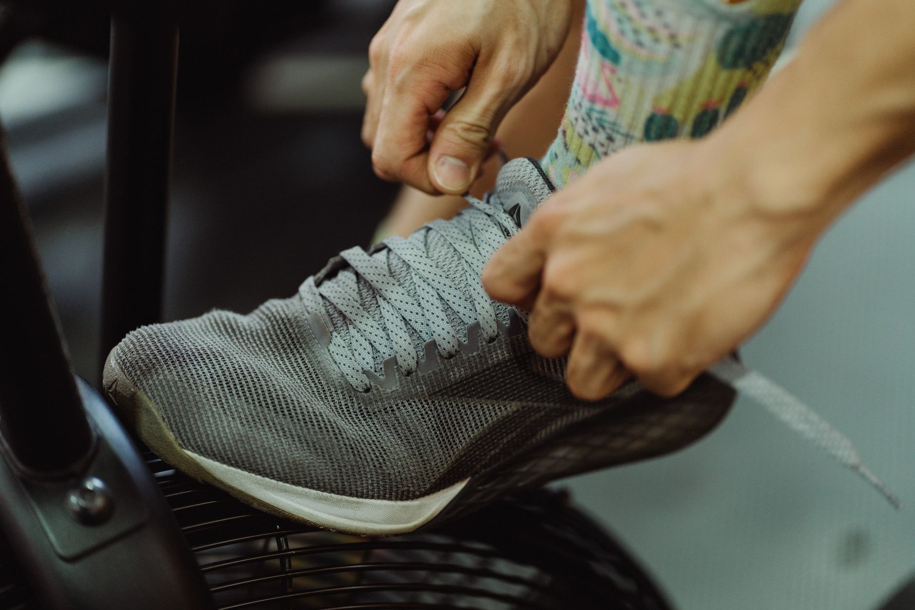 Mains qui nouent les lacets d’une chaussure de running