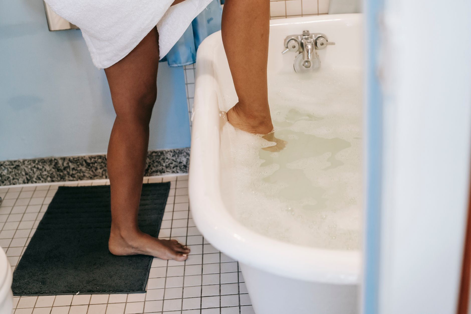 Pieds nus d’une femme enveloppée dans une serviette blanche
